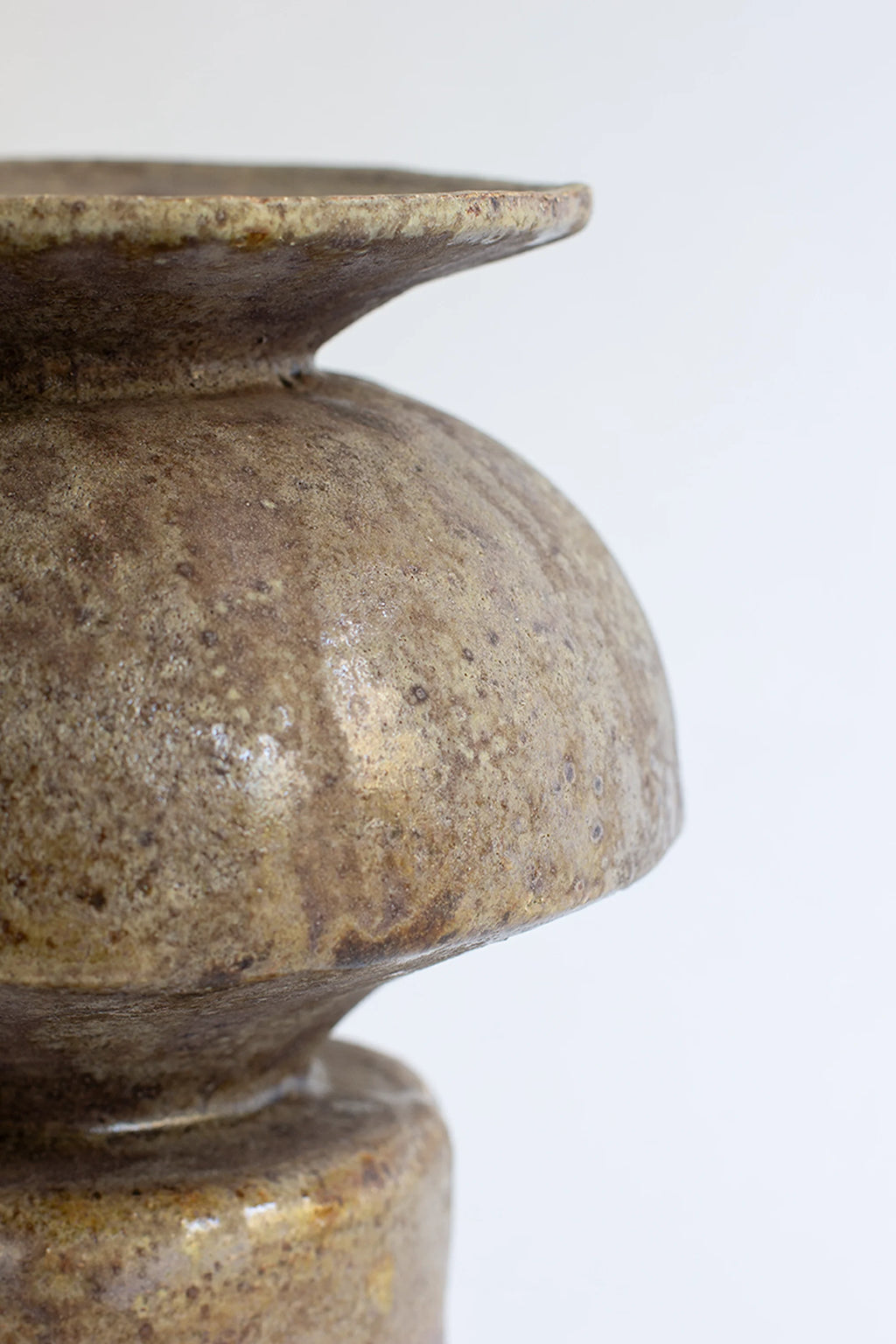 Canoa Lab Psycter Búfalo Vase, a detailed side profile of the handcrafted ceramic vase, highlighting its distinctive tiered shape and the organic, mottled brown and green textured surface, against a white background.