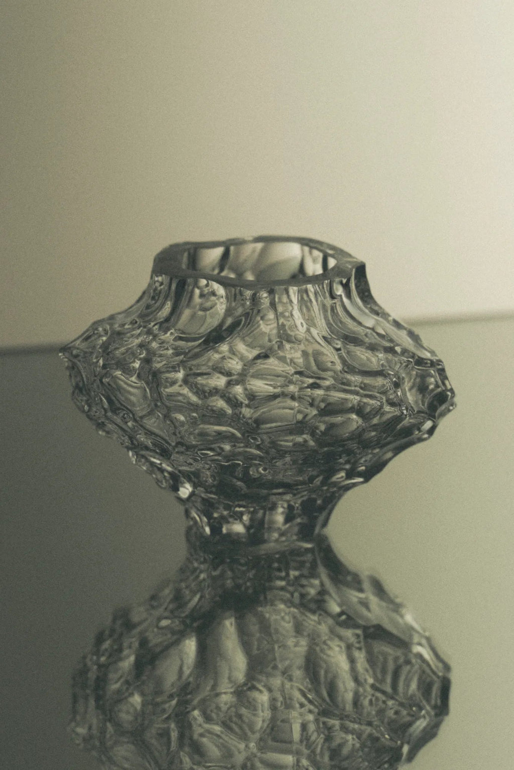 Hein Studio Canyon Vase - Mini, a small sculptural glass vase featuring a unique organic textured surface resembling a raw canyon landscape, crafted from clear molded glass with a wavy, rippled finish. This contemporary and brutalist-inspired decorative object is perfect for minimalist shelf styling, a bedside table accent, or as an artistic centerpiece in modern living rooms.