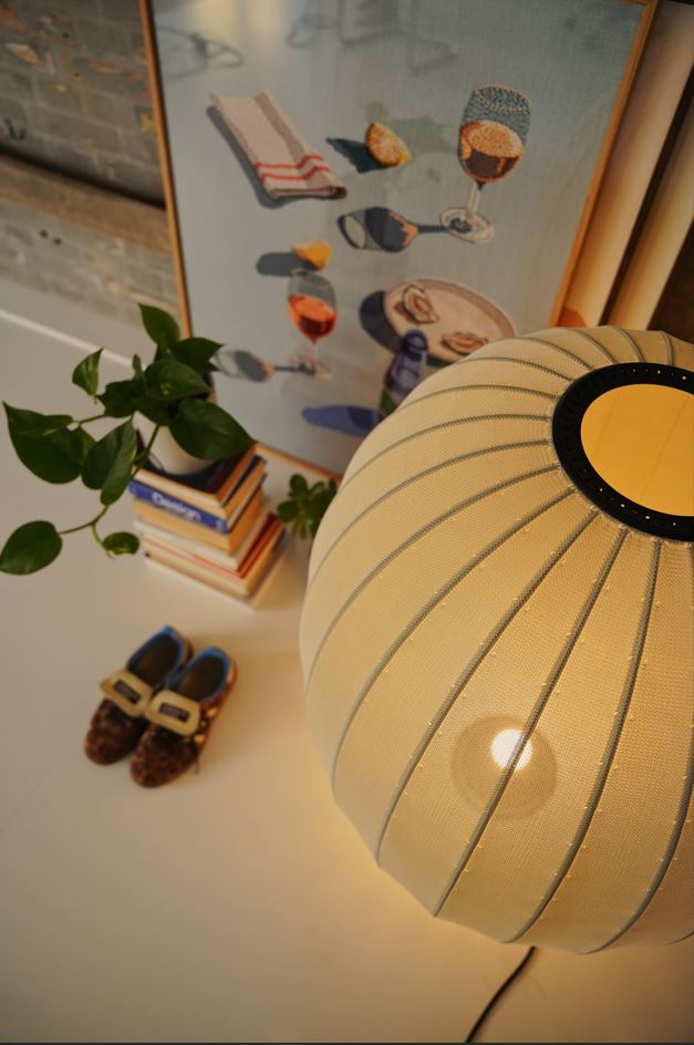 Made by Hand Knit-Wit Ø65 Floor Lamp, a large spherical contemporary floor lamp crafted with a unique knitted textile fabric shade in a warm cream hue, showcasing a distinct ribbed texture.