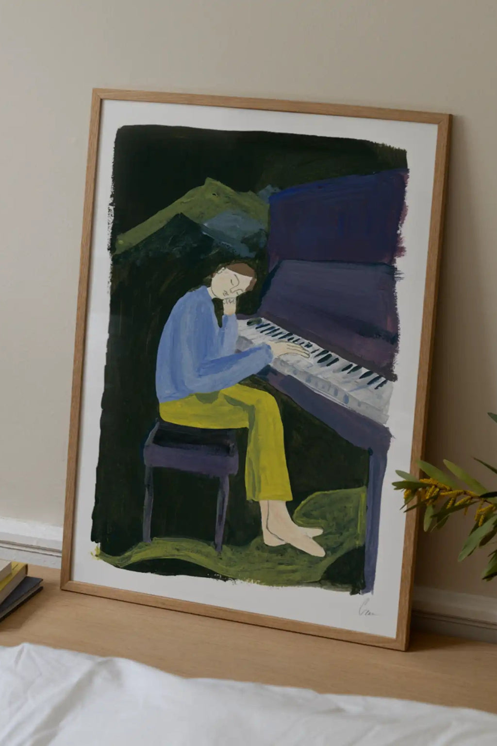 The Poster Club Hania at the Piano, an expressive modern folk art print featuring a figure in a blue top and yellow pants playing a deep purple piano against a dark, painterly green and black background, showcasing visible brush strokes. This contemporary wall art is presented in a light natural oak frame with a crisp white mat, perfect for a minimalist living room, cozy bedroom, or music-themed gallery wall.