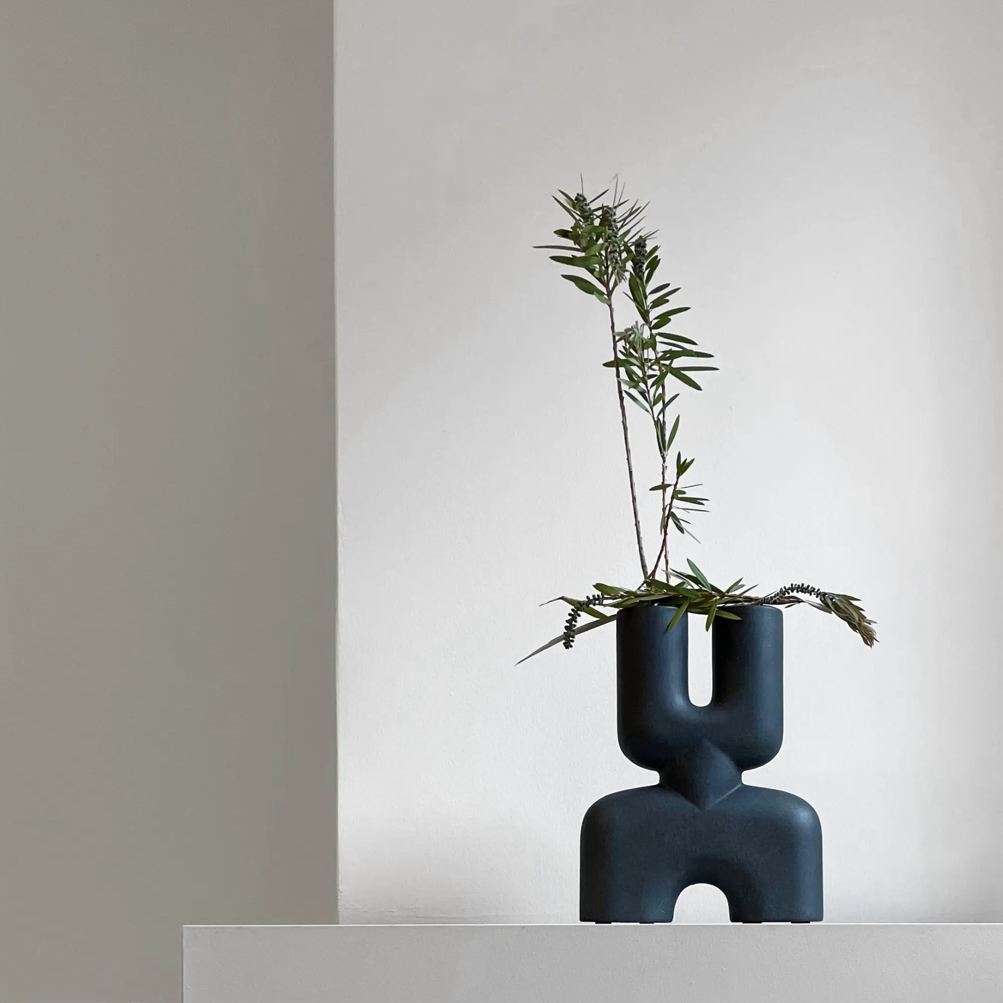 A handcrafted, small-sized ceramic vase featuring a double cobra design