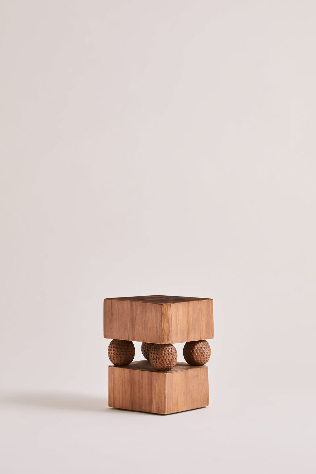 Heaps & Woods Gabi Stool, a sculptural organic modern accent stool crafted from warm natural solid wood, featuring two thick square blocks separated by four deeply textured, dimpled spherical wood elements.