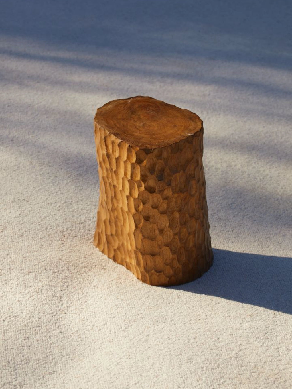 Heaps & Woods Clara Stool, a solid wood stool featuring a warm brown, hand-carved textured finish that evokes an organic tree stump, topped with a smooth, natural wood grain surface.