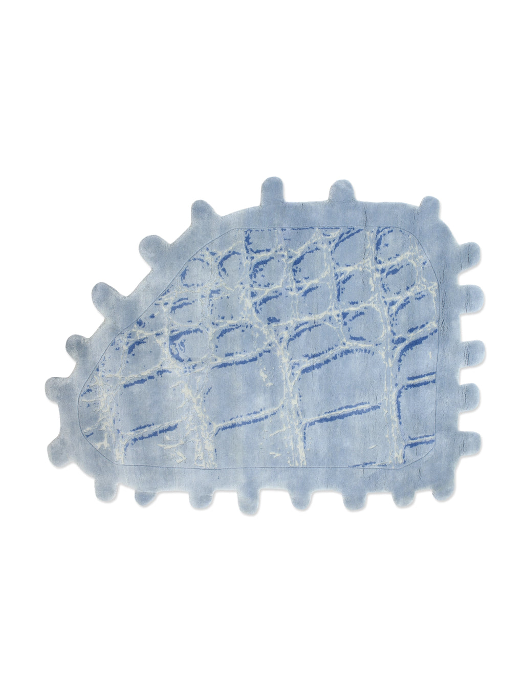 Haus Üger Crocodile Rug, a playful light blue area rug featuring a distinct crocodile skin texture in varying shades of blue and white, with an organic, irregular shape and scalloped edges. This unique, hand-tufted animal print rug adds a whimsical touch, perfect for a modern kids' room, nursery decor, or a creative living space.