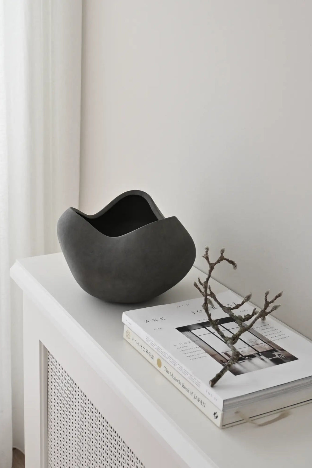 Large white ceramic curve bowl with smooth, rounded edges and a spacious interior for serving or display