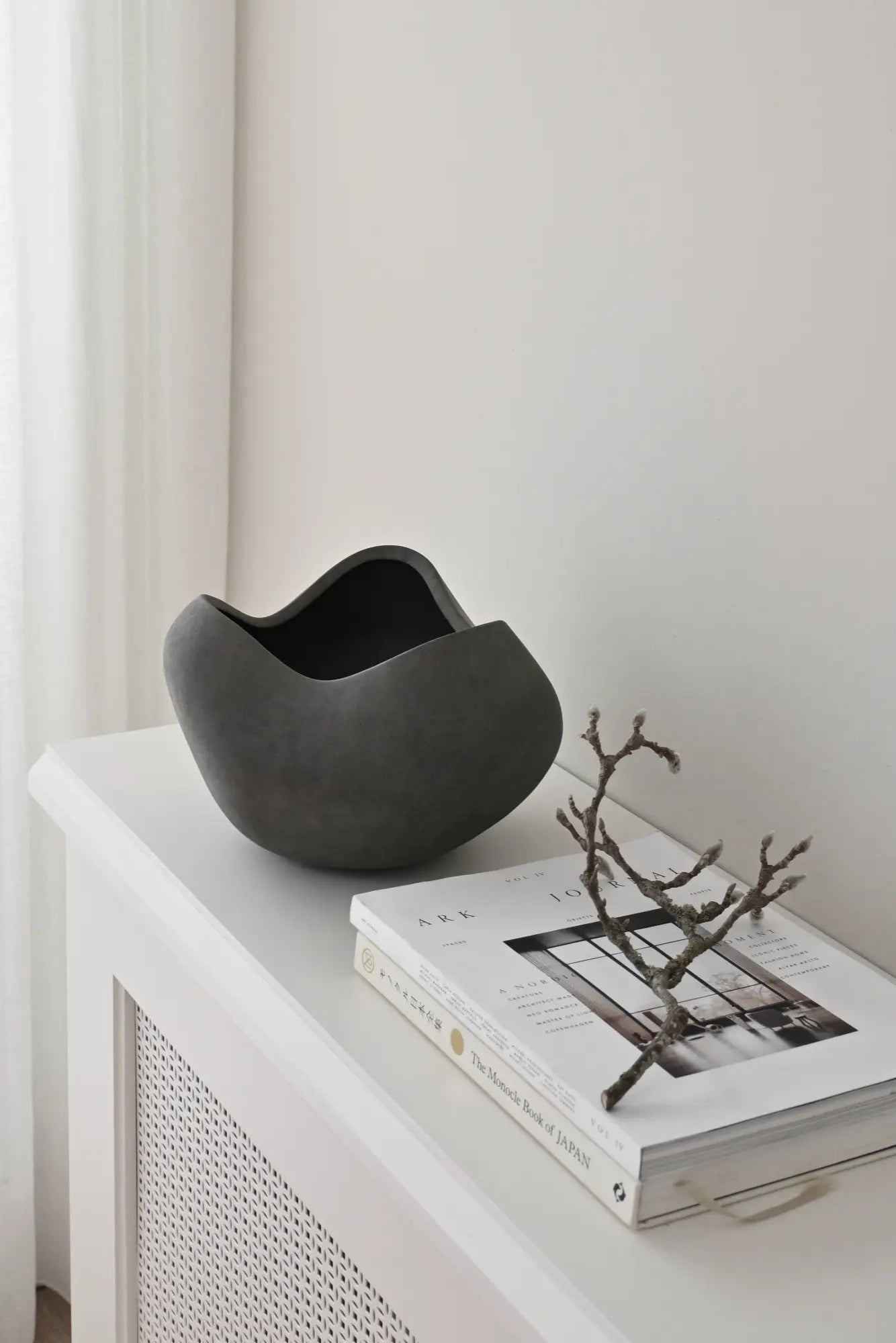 Large white ceramic curve bowl with smooth, rounded edges and a spacious interior for serving or display