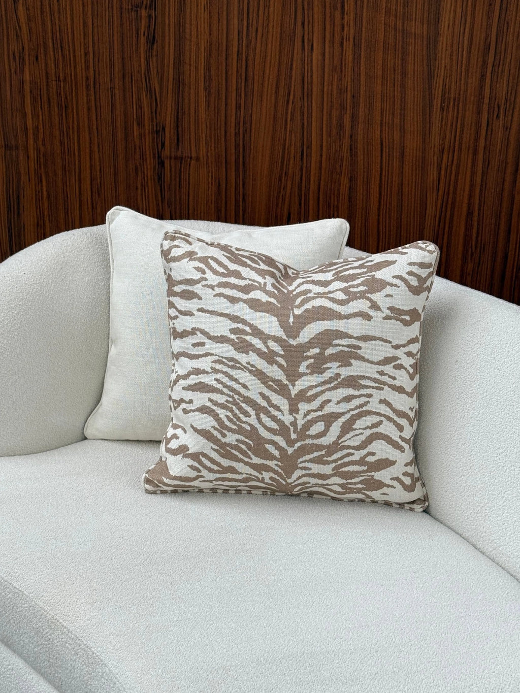 Tinted Objects Norell Throw Pillow, a square accent cushion featuring a natural cream base with a bold, contemporary brown zebra stripe pattern and a textured woven fabric finish.