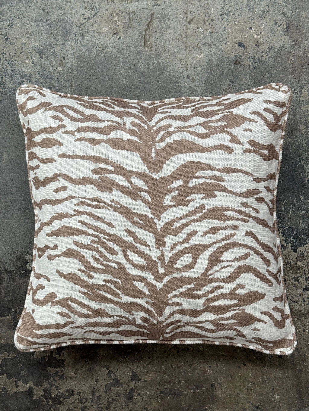 Tinted Objects Norell Throw Pillow, a rectangular decorative cushion featuring a striking taupe and off-white tiger stripe animal print on a textured woven fabric, finished with clean piped edges.