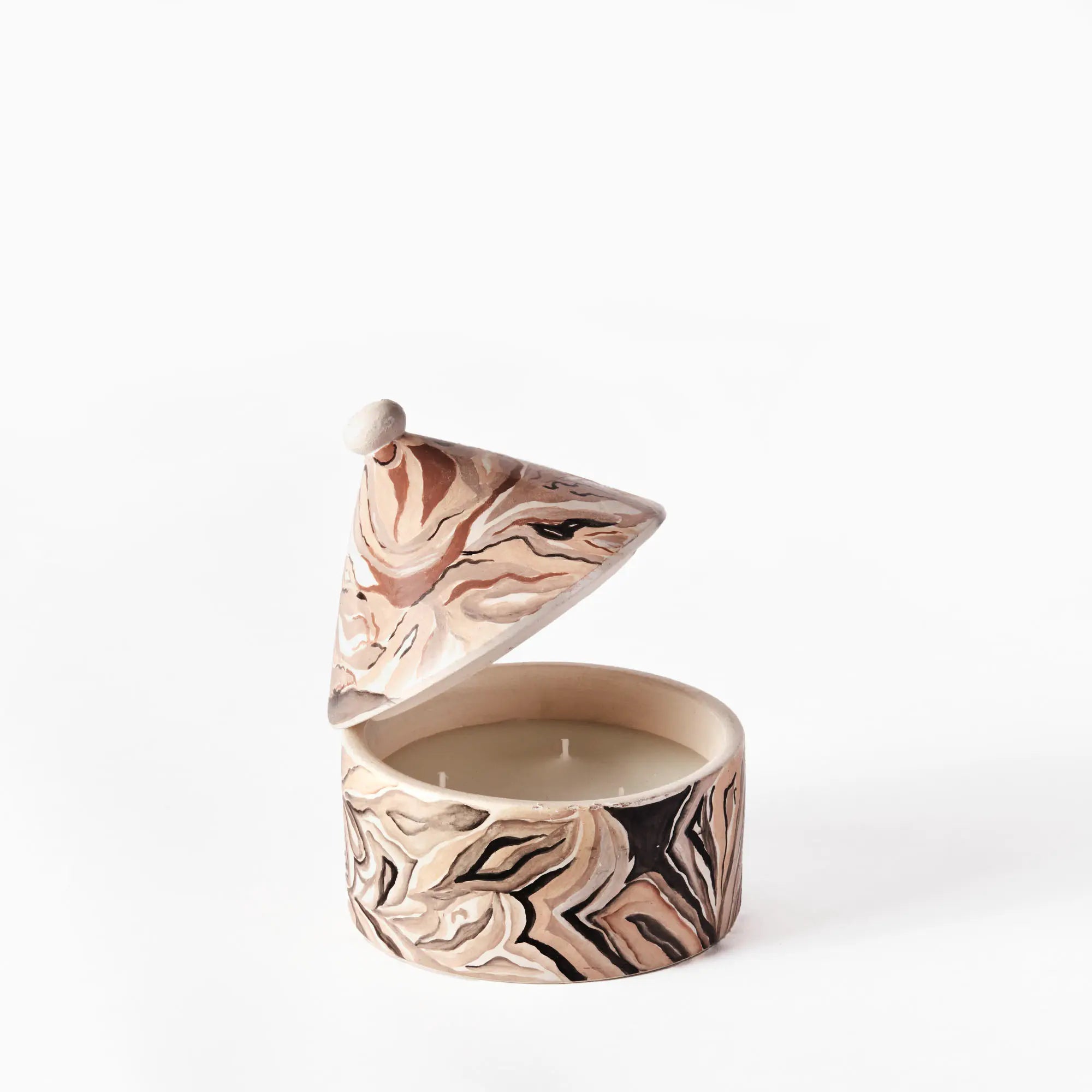 A close-up of Mistral scented candle burning on a cozy table