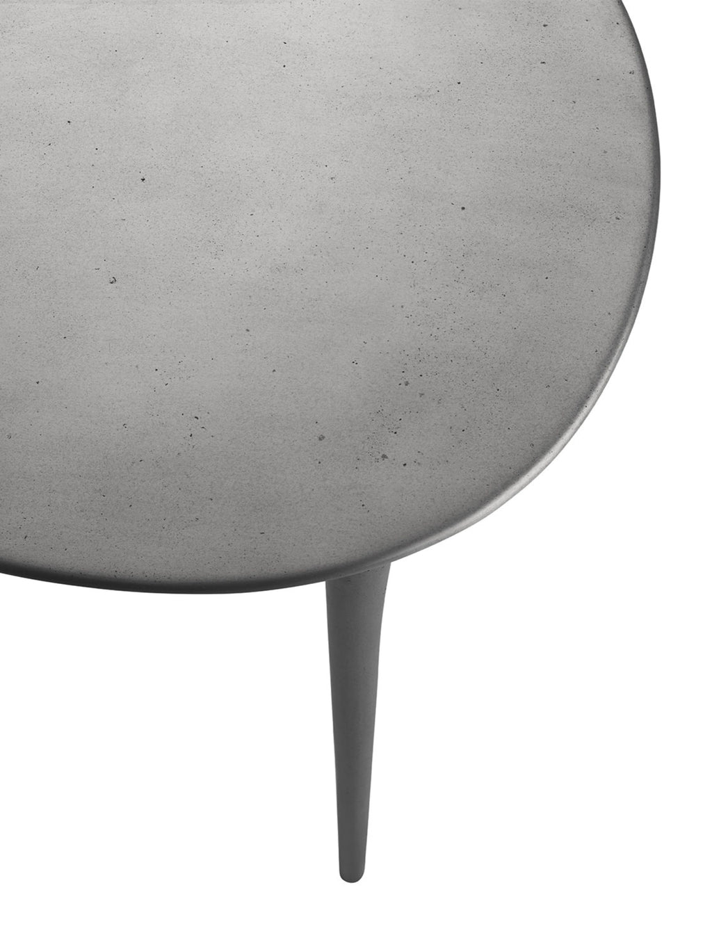 Tine K Dune Recycled Aluminium Desk, a contemporary industrial desk featuring a dark grey round-edged tabletop with a textured, matte concrete-like finish and a sleek tapered leg. Crafted from durable recycled aluminium, this minimalist grey desk offers a raw yet refined aesthetic. Perfect as a stylish home office desk or a brutalist-inspired accent table for modern living spaces.