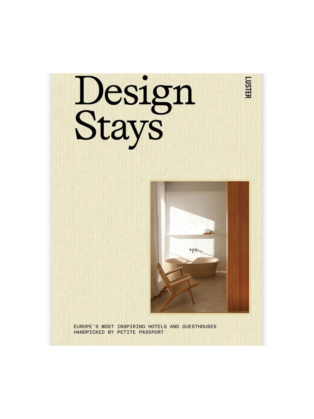 Book Design Stays, a beautiful travel guide with a textured cream-colored cover featuring bold black typography and a photo inset of a stylish modern bathroom with a wooden tub and rattan chair. This inspiring coffee table book is perfect for design enthusiasts and luxury travelers seeking unique accommodations.