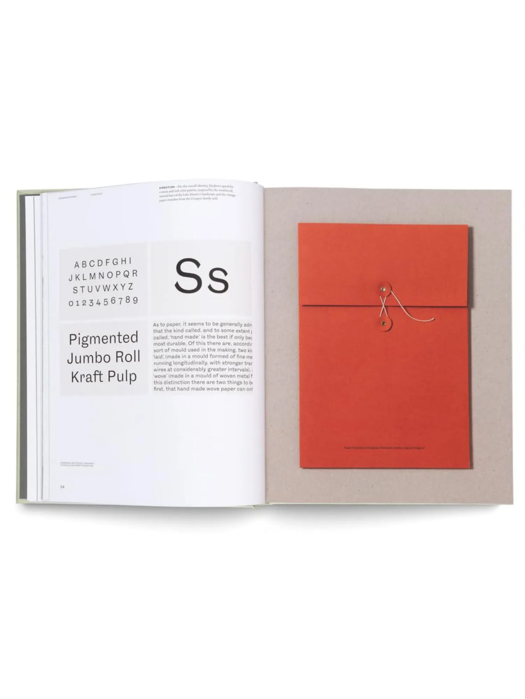 Book Designing Brands, an open, premium hardback book displaying clean white pages with typography examples and a vibrant orange paper envelope bound with string and a button closure. This essential design and branding resource is perfect for graphic designers, marketing professionals, and students seeking creative inspiration.