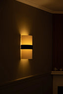Wall-mounted lamp with a warm glow on a dark wall