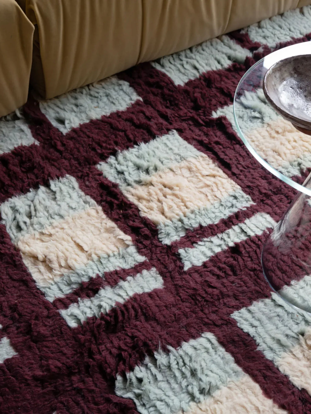 Layered Arbor Shaggy Rug, a plush Moroccan-style area rug featuring a striking geometric pattern of burgundy, light blue, and cream squares and stripes. Perfect for adding warmth and texture to any...