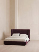 Modern bed with white bedding against a neutral wall