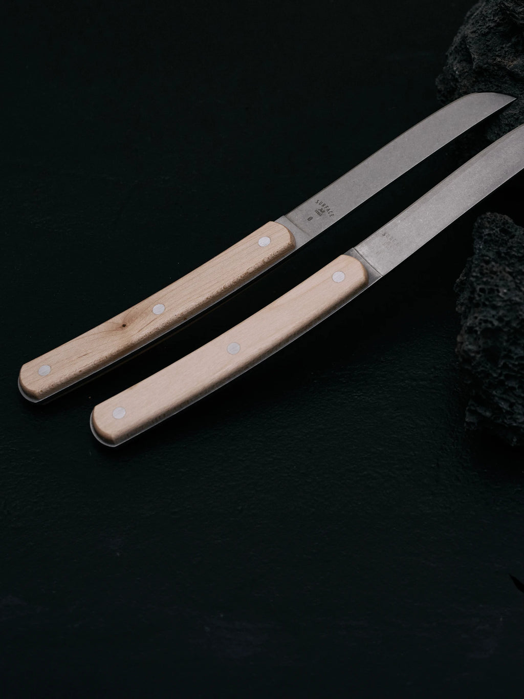 Serax Surface Steak Knife - Set of 4, featuring two premium steak knives with light natural wood handles and exposed silver rivets, paired with durable stainless steel blades. These stylish knives are perfect for home cooks and culinary enthusiasts looking for quality steak cutlery.