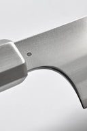 Close-up of a metallic axe head on a light gray background