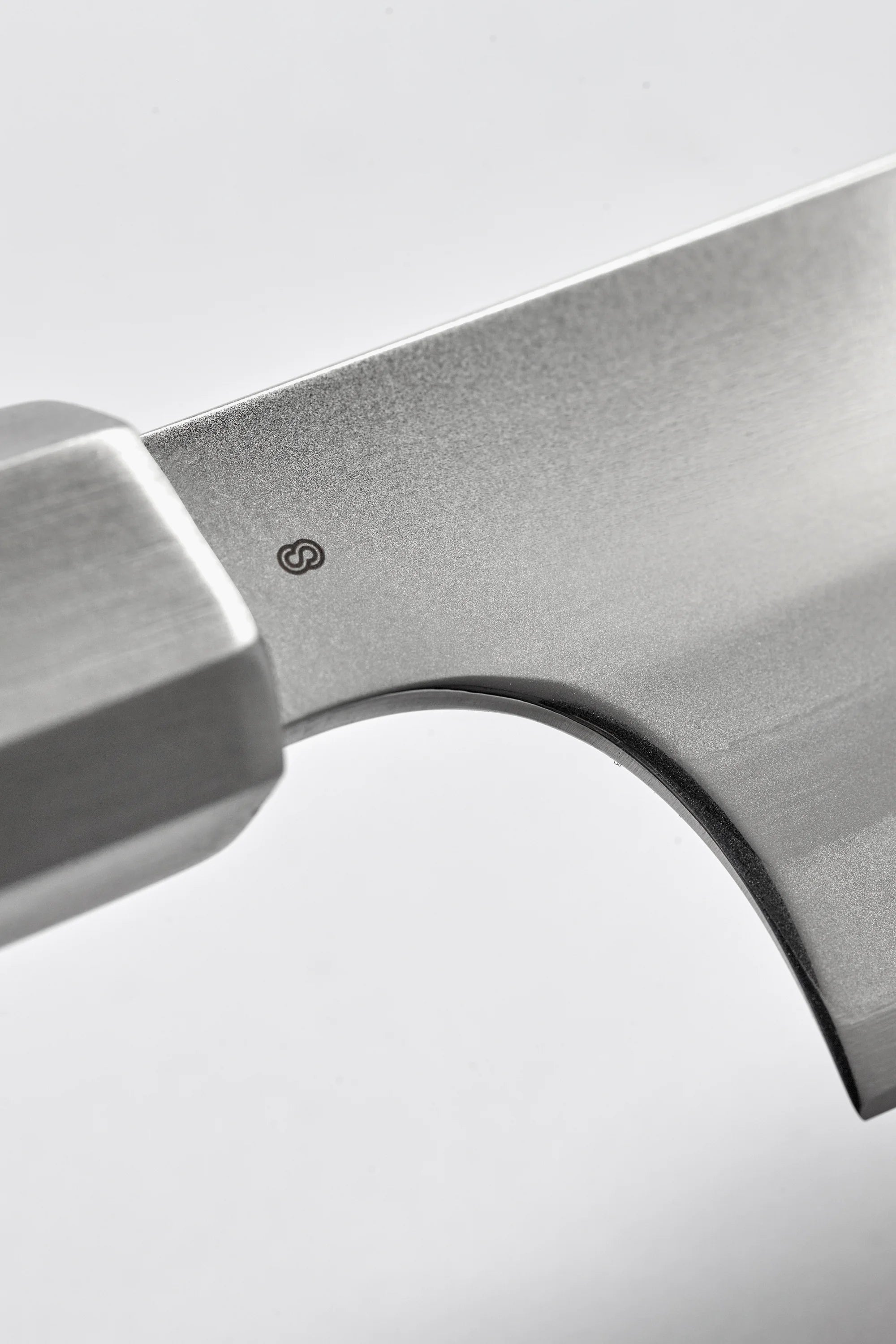 Close-up of a metallic axe head on a light gray background