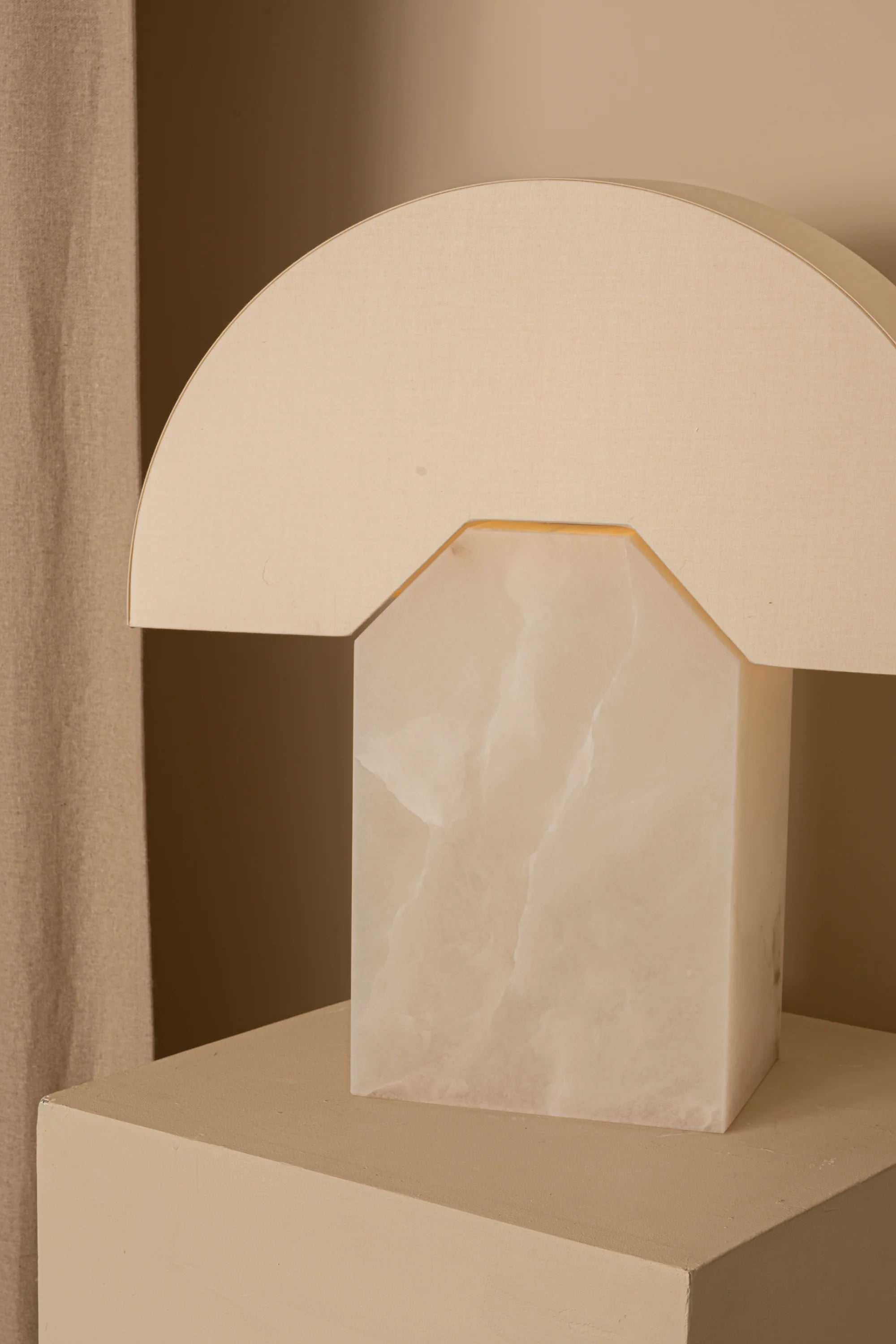 Beige lamp with marble base on a neutral background