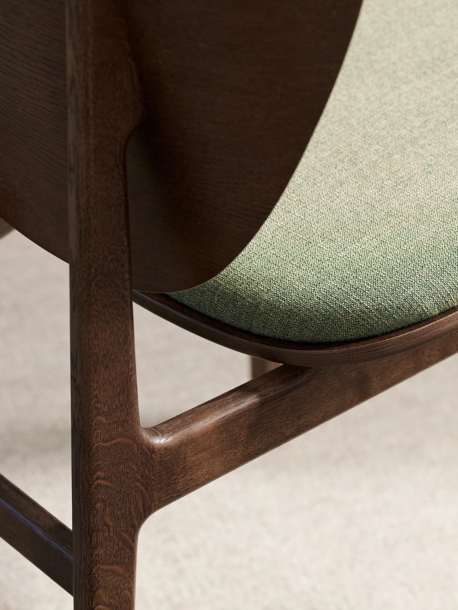NORR11 Elephant Chair, a mid-century modern dining chair featuring a dark stained solid oak wood frame with beautifully curved, organic lines and a finely woven sage green fabric upholstered seat.