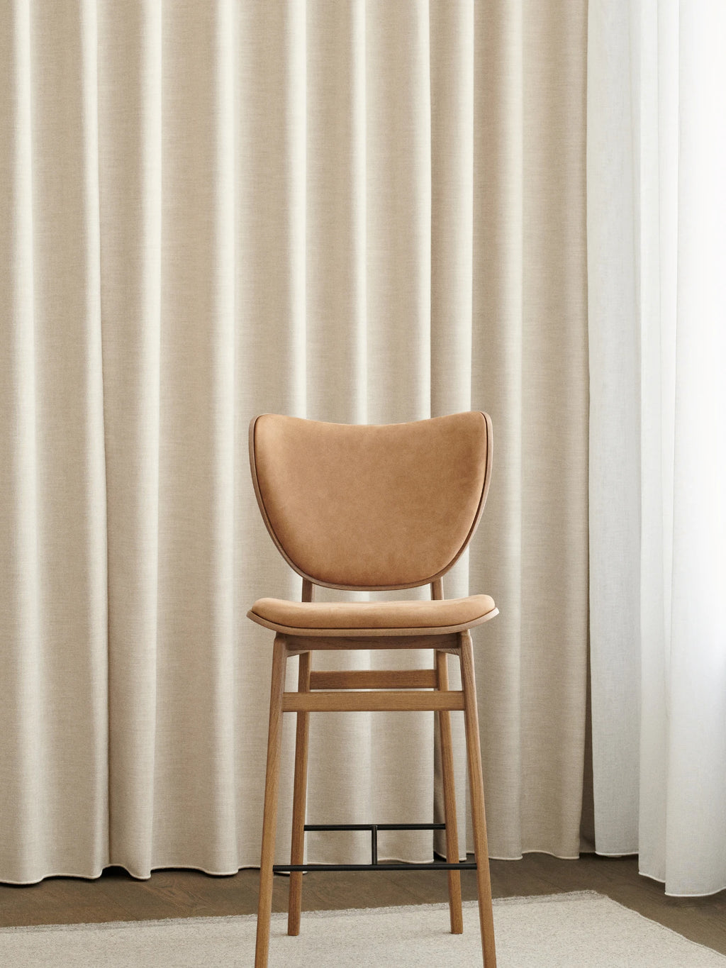 NORR11 Elephant Counter Chair, a modern Scandinavian counter stool featuring a solid oak frame with a gently curved back and seat upholstered in rich tan leather.