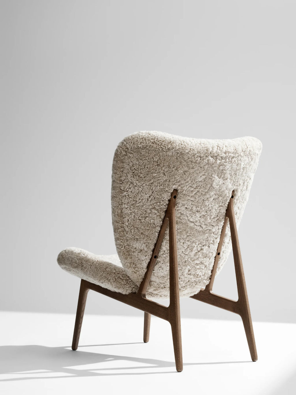 NORR11 Elephant Lounge Chair - Full Upholstery, an elegant lounge chair featuring a plush, cream-colored textural upholstery and a durable, modern wooden frame. This stylish, handcrafted chair is perfect for creating a cozy and luxurious seating area in a sophisticated home.