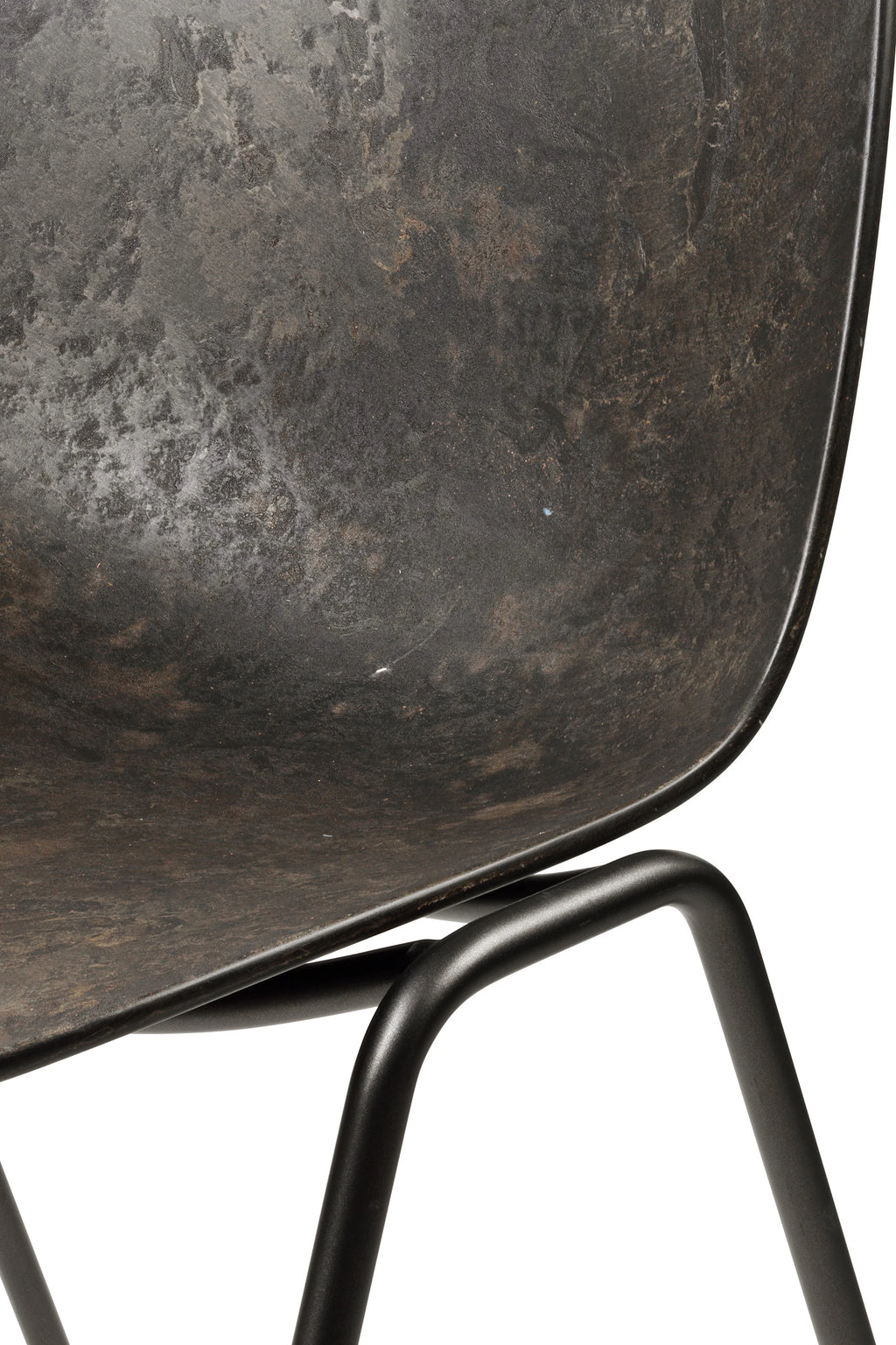Mater Eternity Sidechair, a close-up detail of the dark, textured seat and the connection point to the black metal frame, highlighting the premium material and craftsmanship, on white.