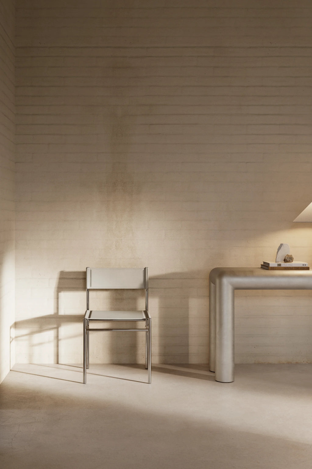 Minimalist chair and table in a softly lit room with wooden walls.