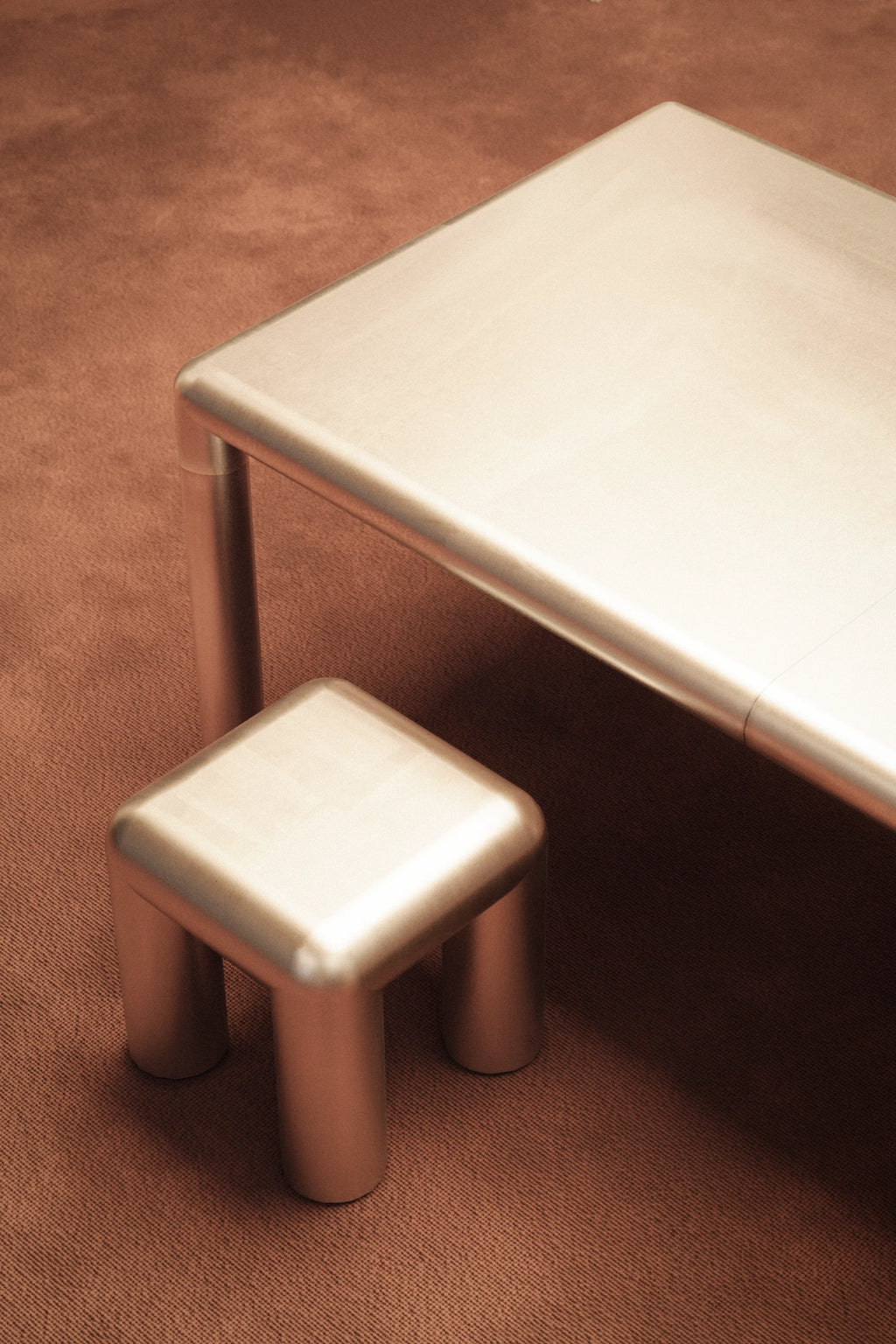 Metallic stool and table on a brown surface