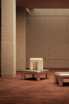 Modern furniture pieces in a room with textured walls and floor.