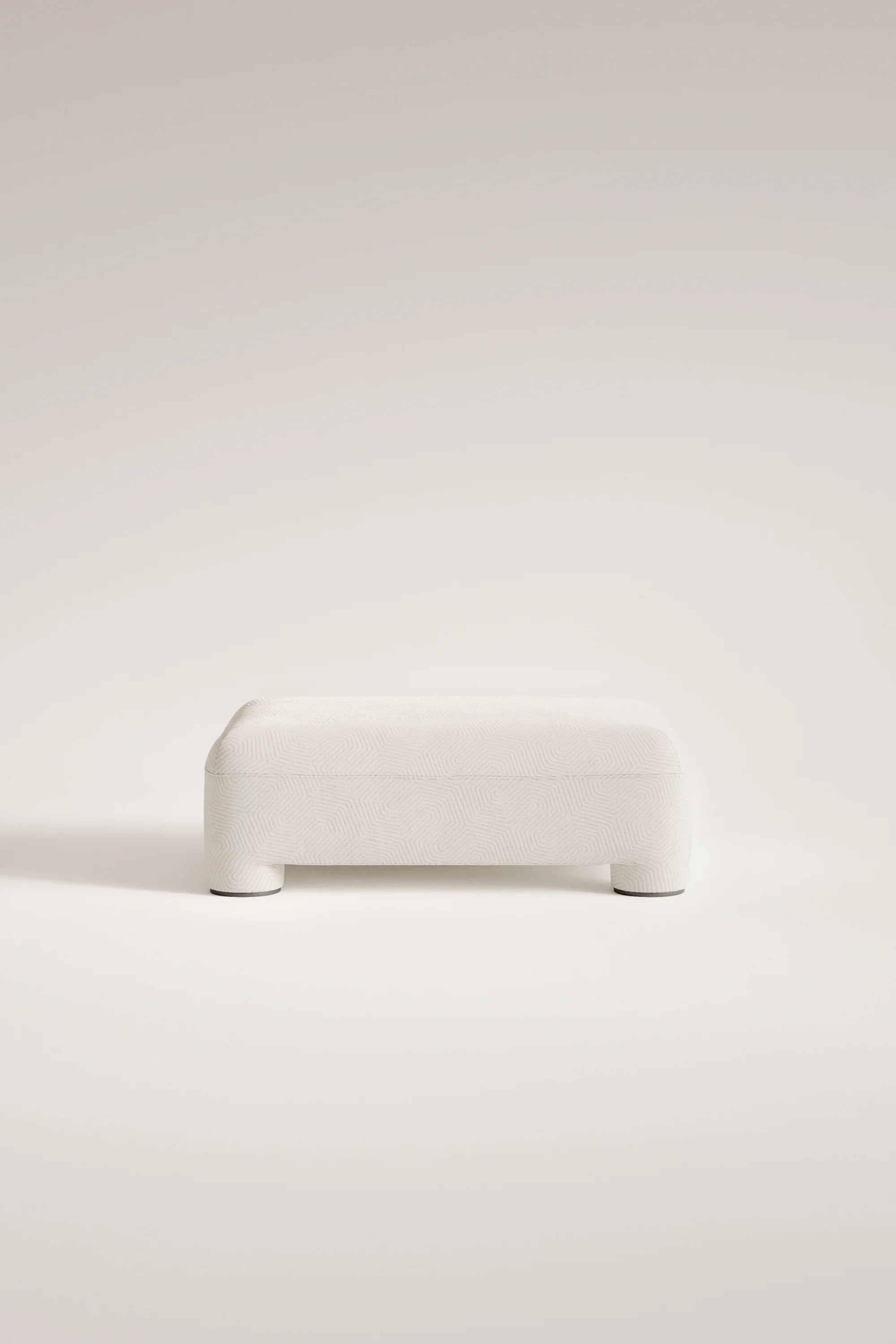 White ottoman on a light beige background