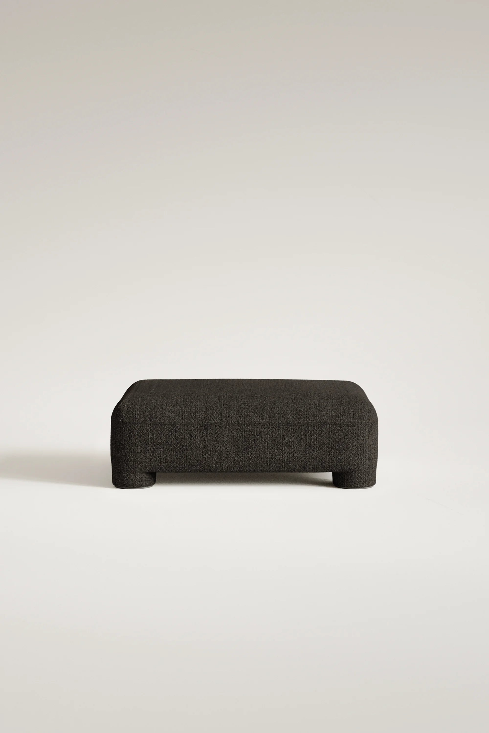 Dark gray ottoman on a light beige background