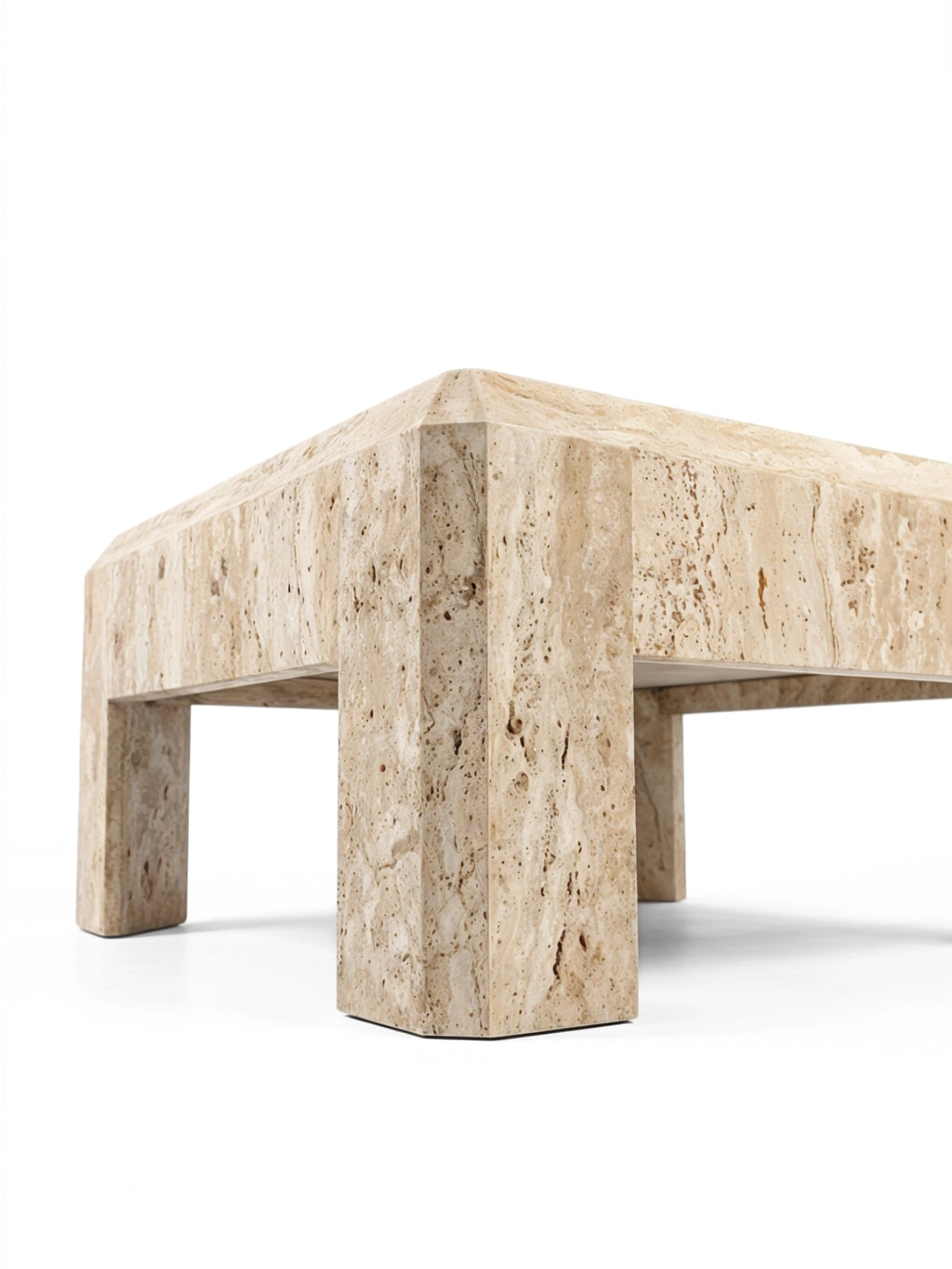 TCL Studios Form Coffee Table, a monumental brutalist travertine coffee table featuring a substantial rectangular top and thick block legs, crafted from natural light beige travertine with a distinctive porous texture and warm organic tones. This sculptural, minimalist design with chamfered edges is perfect for contemporary living rooms seeking an organic modern centerpiece.