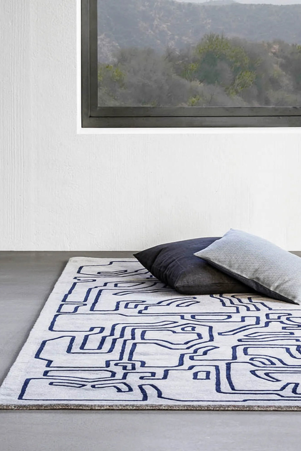 Handwoven wool rug with geometric patterns in shades of blue and gray