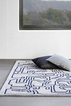 Handwoven wool rug with geometric patterns in shades of blue and gray