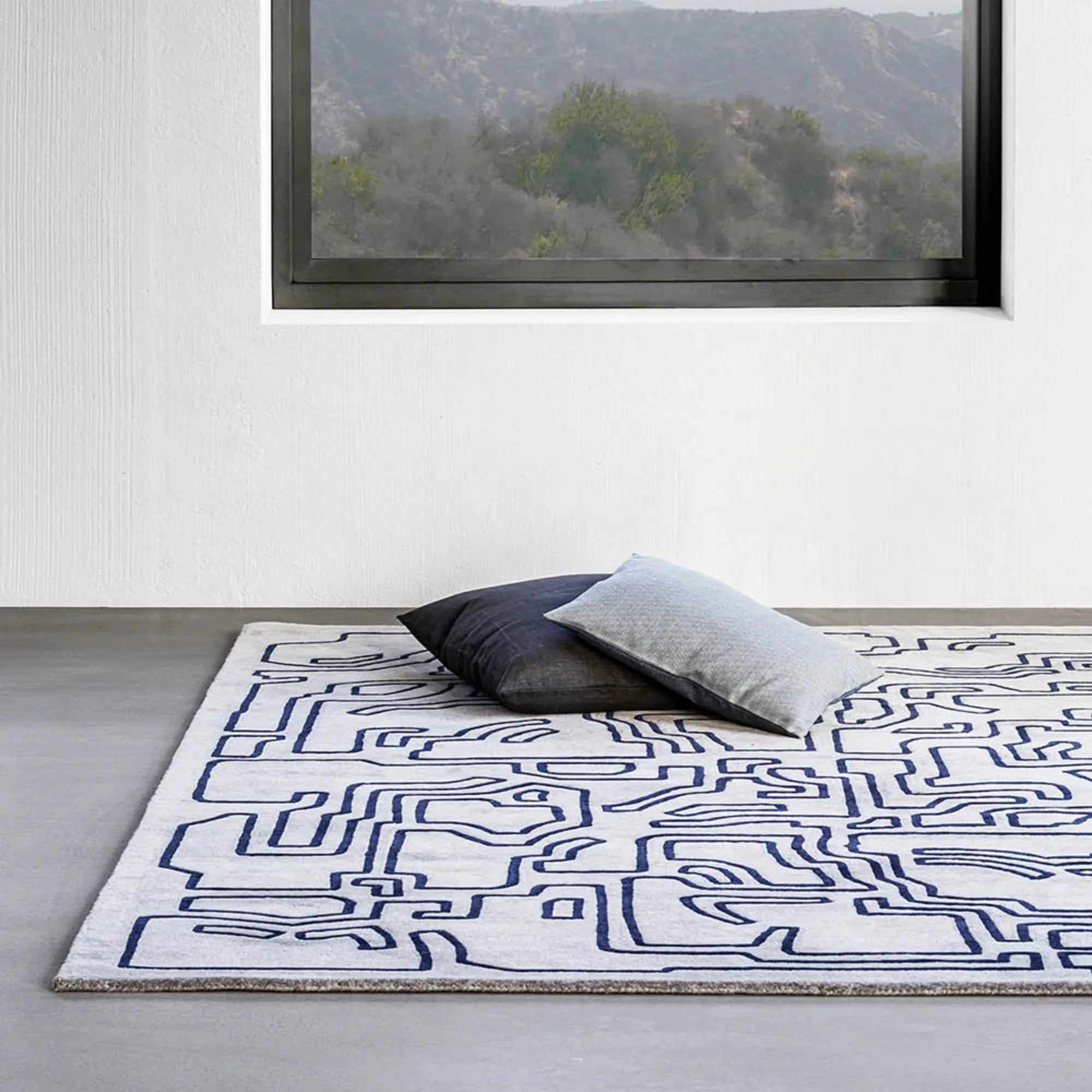 Handwoven wool rug with geometric patterns in shades of blue and gray