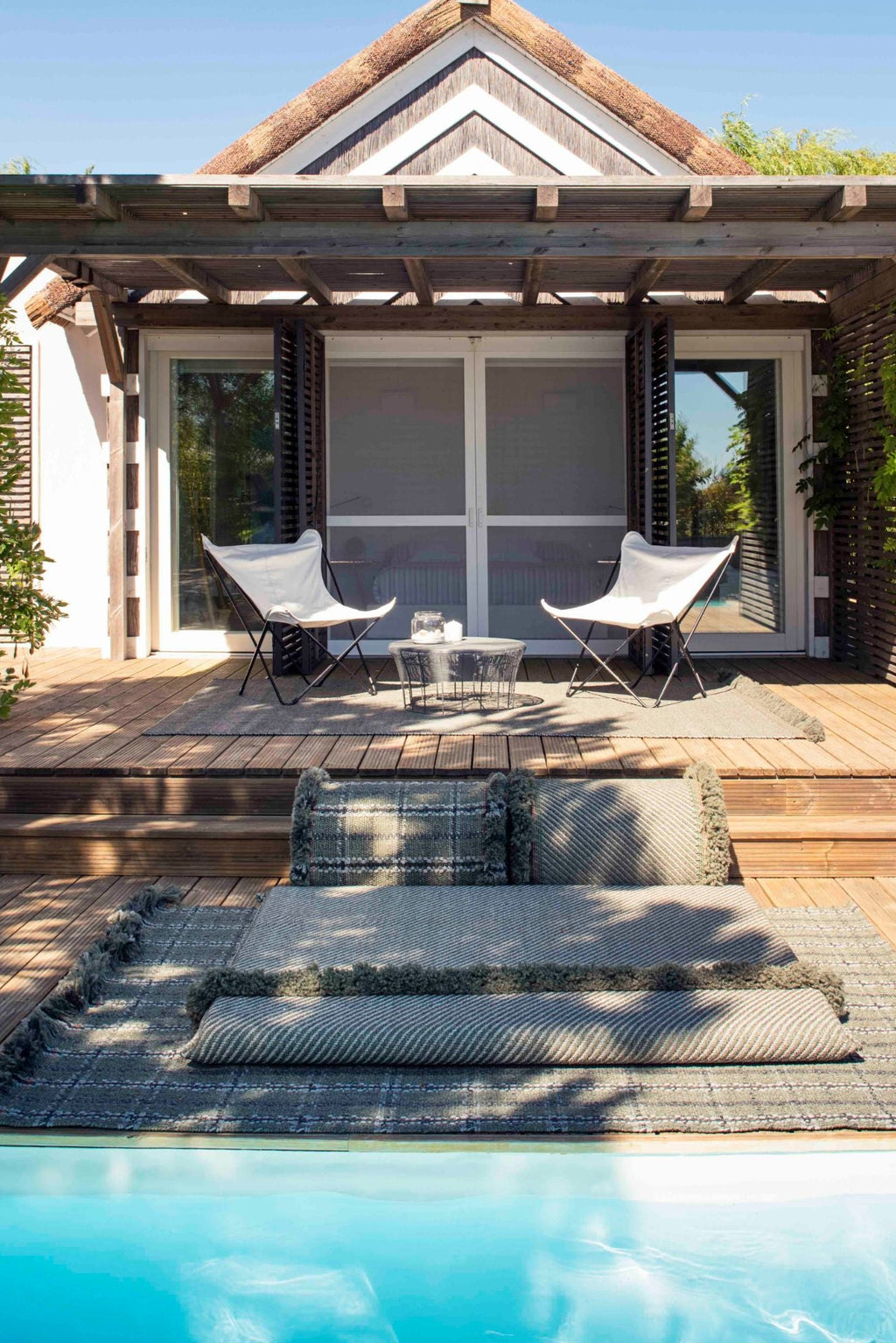 GAN Rugs Garden Layers Composition 03, a luxurious modular outdoor sofa system featuring a muted grey-green color palette with textured woven cushions and a matching base rug.