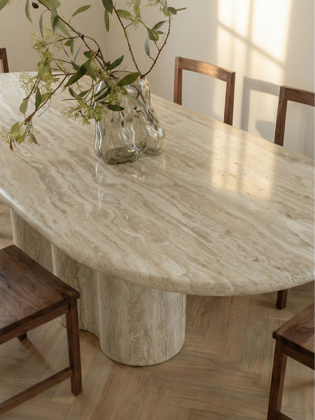 TCL Studios Galatea Travertine Dining Table, an elegant oval dining table crafted from natural light cream travertine with distinctive warm veining and a smooth, sculptural curved pedestal base.