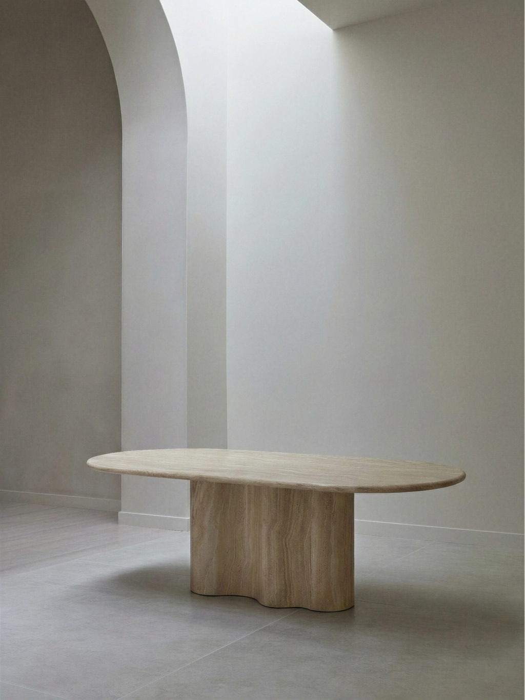 TCL Studios Galatea Travertine Dining Table, an organic modern dining table crafted from natural light beige travertine with a smooth oval tabletop and a distinctive sculptural, wavy pedestal base showcasing the stone's unique veining. This minimalist natural stone dining table is perfect as a statement piece for contemporary dining rooms or luxurious kitchen spaces.