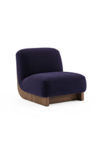 Laskasas Gandhi Lounge Chair, a sophisticated contemporary lounge chair featuring plush deep purple velvet upholstery with a gently curved backrest and low-profile seat. It rests on a substantial dark brown solid wood base, showcasing a rich wood grain and a subtle organic curved detail at the front. Ideal as a luxurious accent chair for modern minimalist living rooms or a chic reading nook in a contemporary bedroom.
