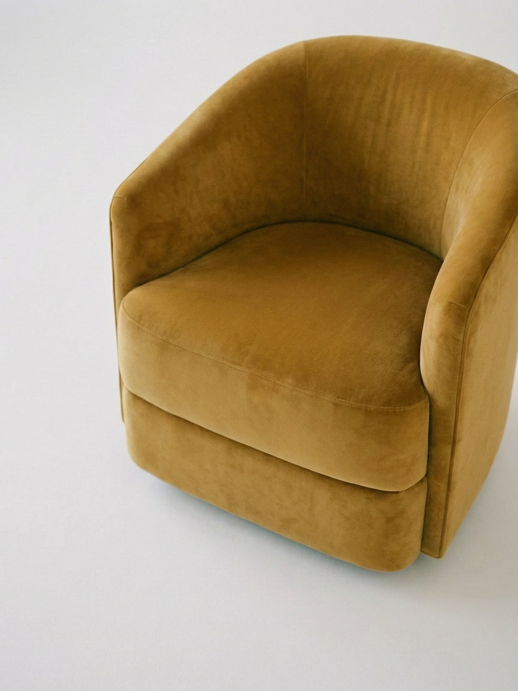 New Works Covent Lounge Chair - Narrow. Luxurious mustard velvet upholstered armchair with curved back and subtle seams, displayed on a white studio background. Ideal for a chic modern living space.