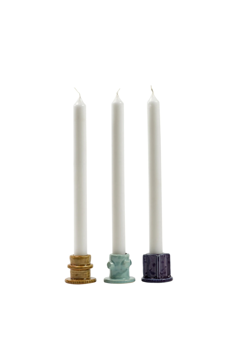 Serax Glazed Molly Candle Holder 01 - Set of 3, featuring three unique ceramic taper candle holders in glossy mustard yellow, teal green, and deep indigo blue glazes, each with distinct sculpted details, holding white taper candles. These stylish decorative candle holders are perfect for adding a touch of modern charm to any home decor enthusiast's living space or dining table.