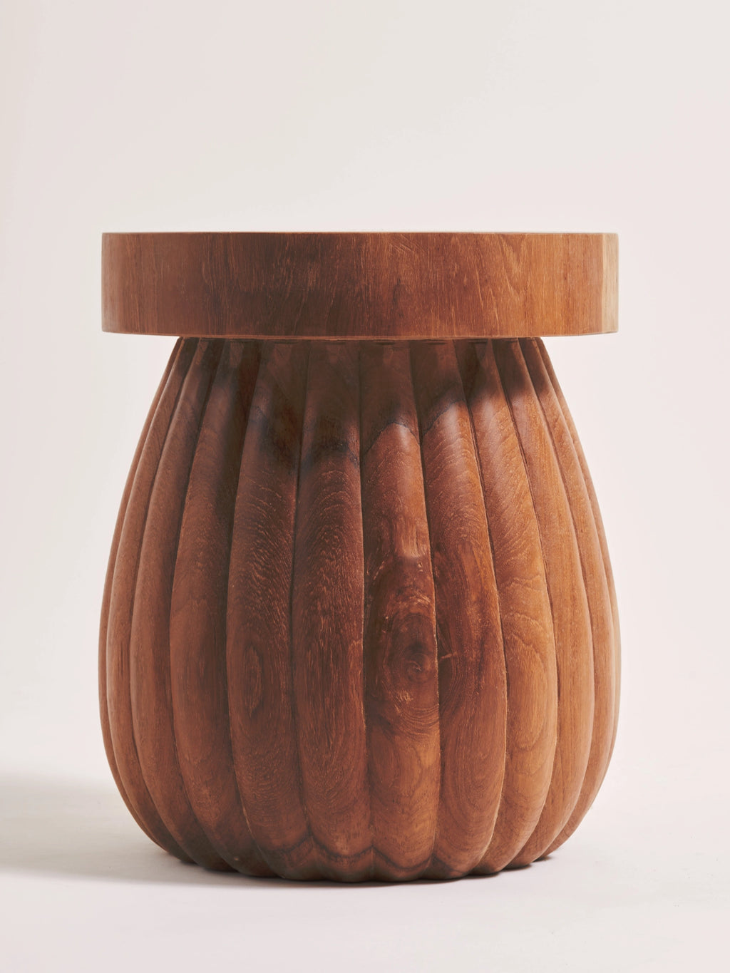 Heaps & Woods Charlotte Stool, a sculptural organic modern accent piece crafted from warm brown solid wood, featuring a smooth round top and a distinctive fluted, bulbous base with deep vertical carvings.