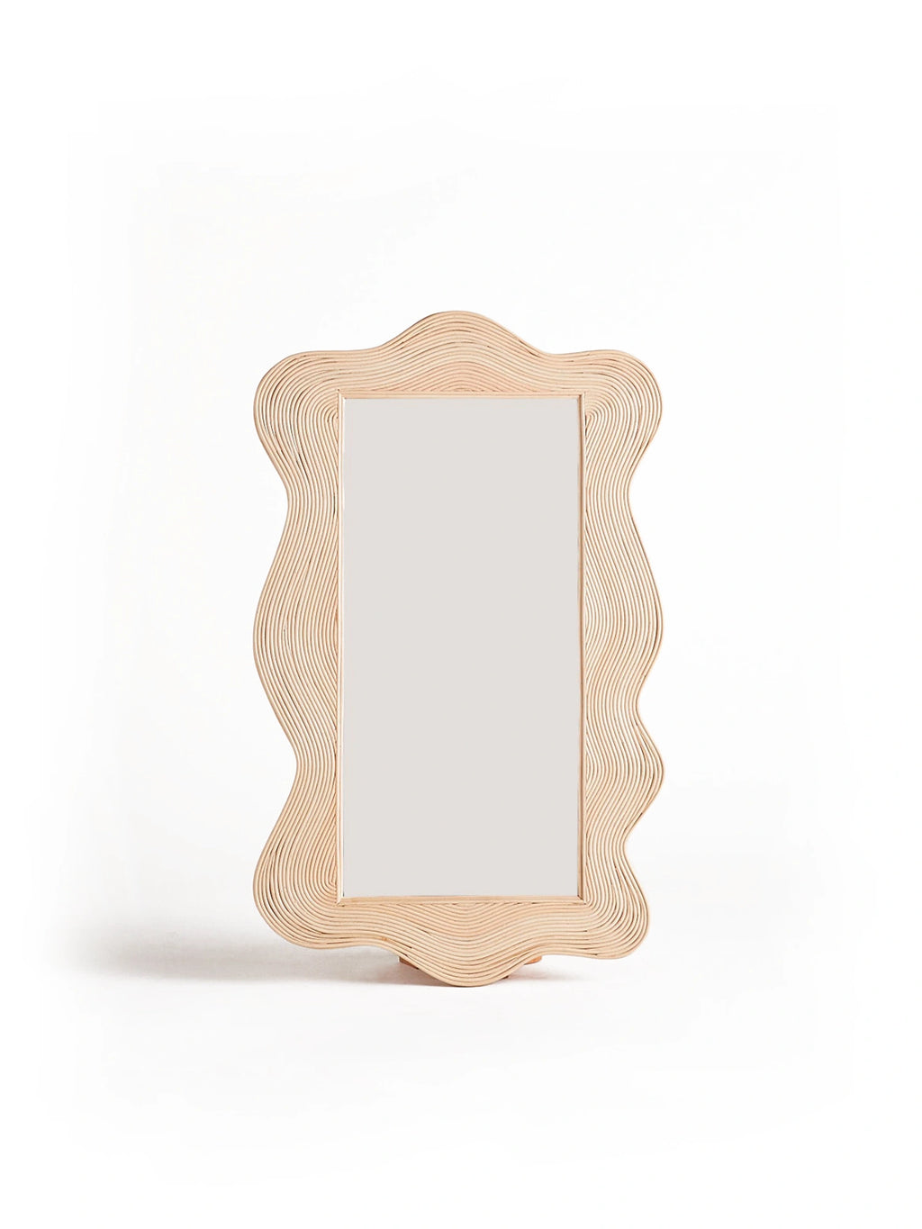 Heaps & Woods Sofia Mirror, a handcrafted natural blonde rattan tabletop mirror featuring a distinctive wavy organic frame crafted from layered bent rattan strips. This contemporary decorative mirror showcases a unique scalloped silhouette, perfect for boho or organic modern bedroom dresser styling or a chic vanity.