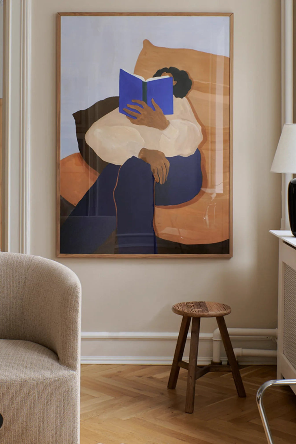 The Poster Club The Togo, an abstract figurative art print showcasing a person engrossed in a blue book, rendered with a contemporary minimalist aesthetic and a soft color palette of muted blue, warm browns, cream,.