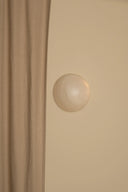 Close-up of a beige cabinet with a round knob on a beige background