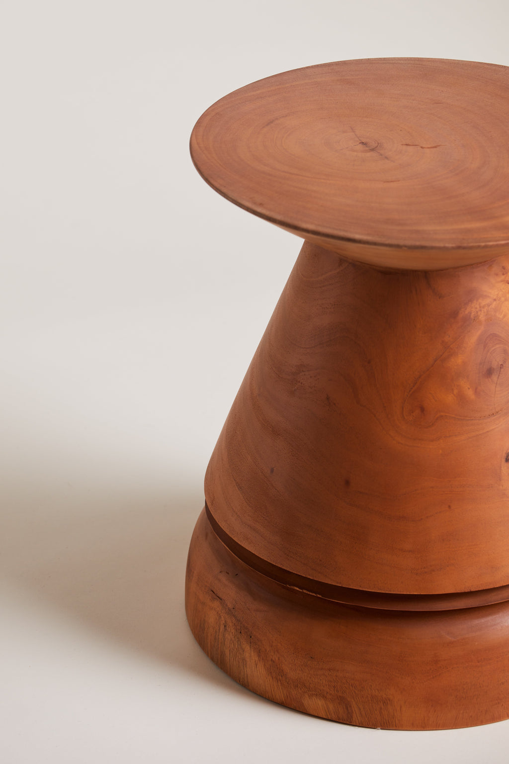 Heaps & Woods Lilu Stool, a sculptural organic modern solid wood stool crafted from rich reddish-brown wood with visible natural grain and a smooth finish.