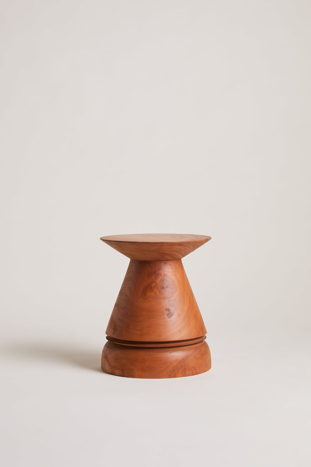 Heaps & Woods Lilu Stool, a sculptural solid wood stool featuring a distinctive turned wood design with a conical top and base, showcasing rich natural reddish-brown wood tones and visible grain. This organic modern accent piece serves as a versatile side table or decorative object, perfect for minimalist living rooms, contemporary bedrooms, or japandi-style spaces.