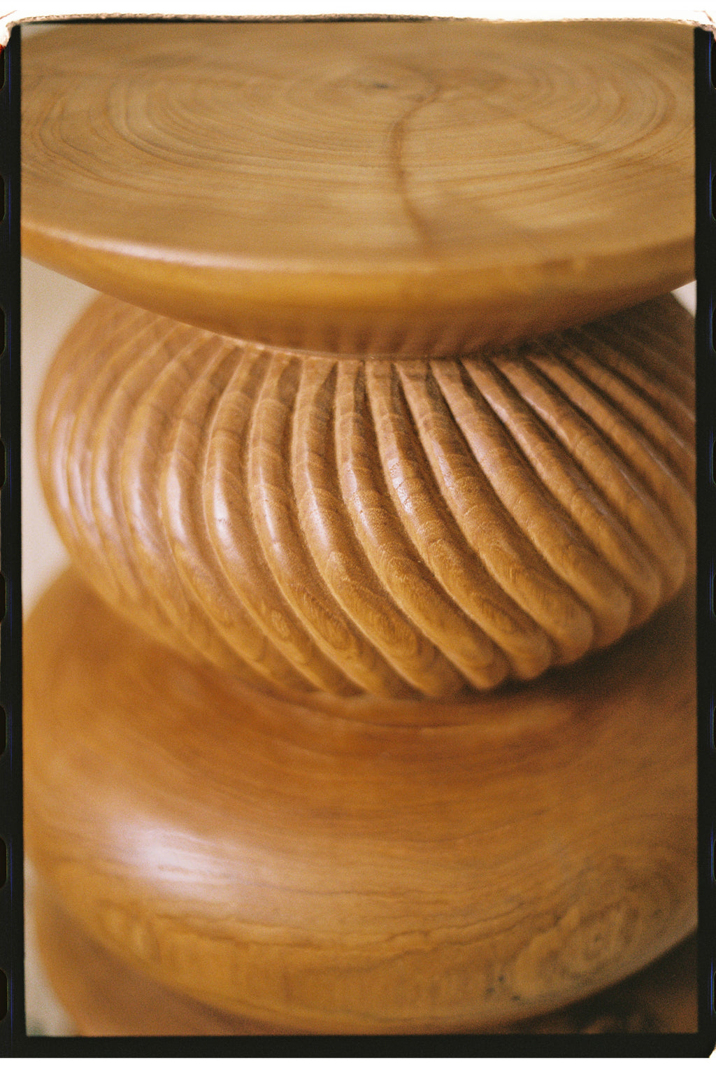 Heaps & Woods Nala Stool, a sculptural solid wood stool crafted from warm honey-brown wood with a smooth round top and base, featuring a distinctive deeply carved ribbed central section. This organic modern accent stool offers natural texture and contemporary design, perfect as a bedside table, living room side table, or decorative piece for minimalist and Japandi interiors.