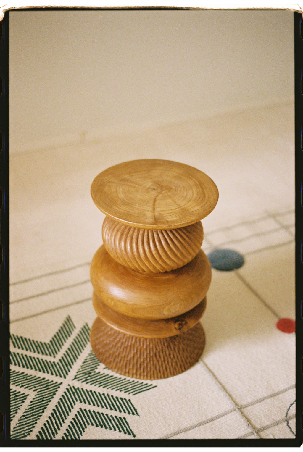 Heaps & Woods Nala Stool, a sculptural organic modern accent stool crafted from warm natural solid wood with a distinctive stacked design. This handcrafted piece features a smooth top with visible wood grain, a fluted central body, and a ribbed base, all in a light honey-toned finish.